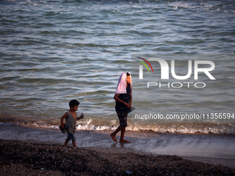 Displaced Palestinians are being seen on the beach in Deir el-Balah in the central Gaza Strip on June 24, 2024, amid the ongoing conflict be...