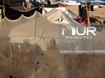 Displaced Palestinian children are looking outside their tent at the beach in Deir el-Balah, central Gaza Strip, on June 24, 2024, amid the...