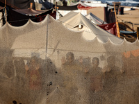 Displaced Palestinian children are looking outside their tent at the beach in Deir el-Balah, central Gaza Strip, on June 24, 2024, amid the...