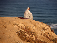 A displaced Palestinian woman is being seen on the beach in Deir el-Balah in the central Gaza Strip on June 24, 2024, amid the ongoing confl...