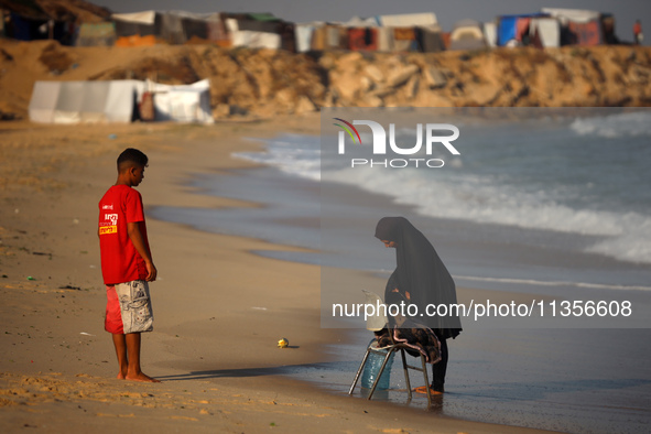 A Palestinian woman is washing clothes at the beach in Deir el-Balah, central Gaza Strip, on June 24, 2024, amid the ongoing conflict betwee...