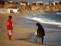 A Palestinian woman is washing clothes at the beach in Deir el-Balah, central Gaza Strip, on June 24, 2024, amid the ongoing conflict betwee...