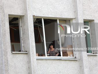 A woman is talking on the phone as seen through a knocked-out window at the Ivano-Frankivsk National Technical University of Oil and Gas, da...