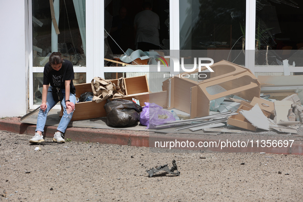 A woman is sitting by the pile of broken furniture at the Ivano-Frankivsk National Technical University of Oil and Gas damaged by a Russian...