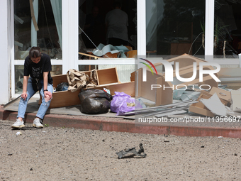 A woman is sitting by the pile of broken furniture at the Ivano-Frankivsk National Technical University of Oil and Gas damaged by a Russian...