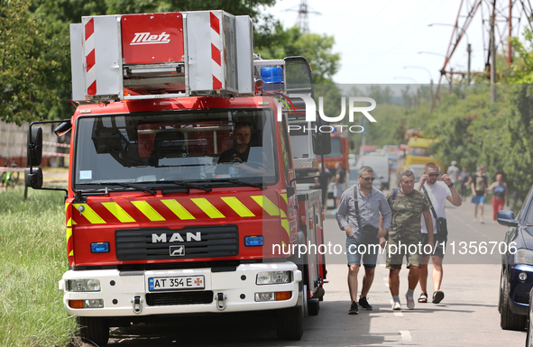 People are walking past a fire engine near the Ivano-Frankivsk National Technical University of Oil and Gas, which is damaged by a Russian m...