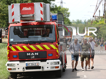 People are walking past a fire engine near the Ivano-Frankivsk National Technical University of Oil and Gas, which is damaged by a Russian m...