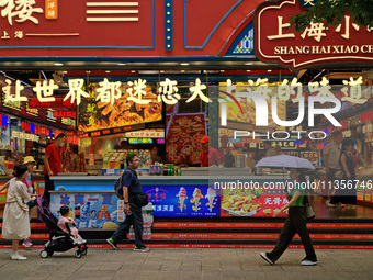 Chinese and foreign tourists are bustling along the Nanjing Road Pedestrian street in Shanghai, China, on June 24, 2024. (