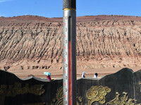 Tourists are visiting the Flaming Mountain scenic spot in Turpan, Xinjiang province, China, on June 24, 2024. A golden stick-shaped thermome...