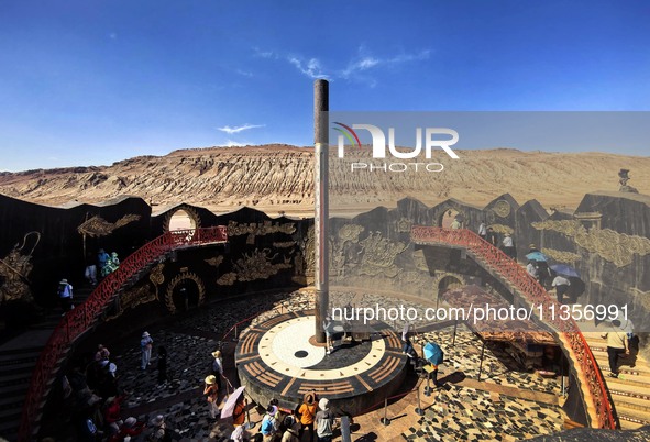 Tourists are visiting the Flaming Mountain scenic spot in Turpan, Xinjiang province, China, on June 24, 2024. A golden stick-shaped thermome...