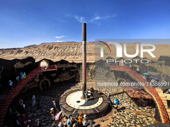 Tourists are visiting the Flaming Mountain scenic spot in Turpan, Xinjiang province, China, on June 24, 2024. A golden stick-shaped thermome...