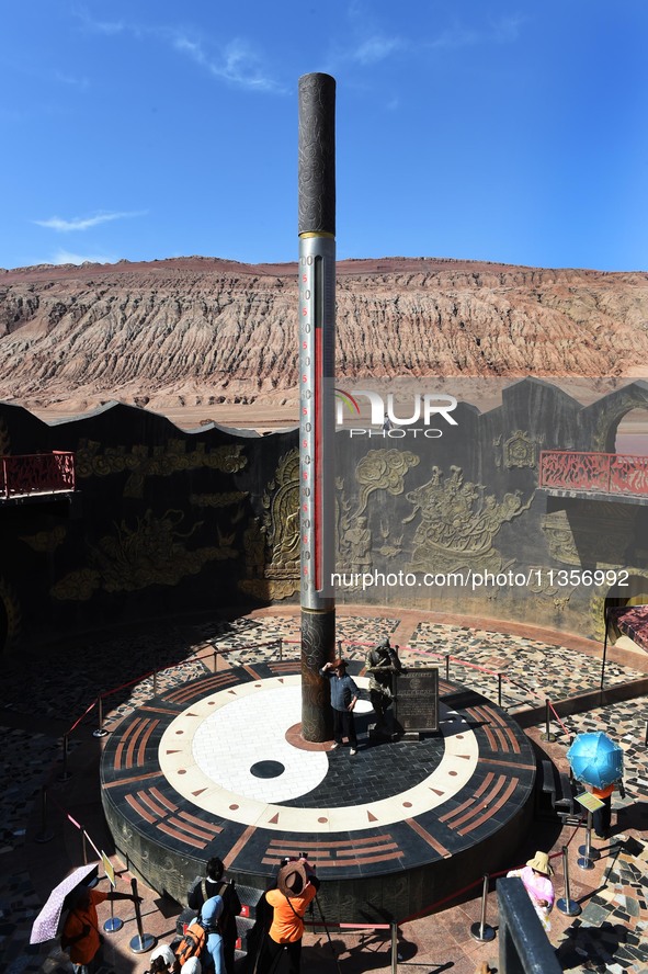 Tourists are visiting the Flaming Mountain scenic spot in Turpan, Xinjiang province, China, on June 24, 2024. A golden stick-shaped thermome...