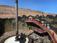 Tourists are visiting the Flaming Mountain scenic spot in Turpan, Xinjiang province, China, on June 24, 2024. A golden stick-shaped thermome...