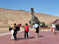 Tourists are visiting the Flaming Mountain scenic spot in Turpan, Xinjiang province, China, on June 24, 2024. A golden stick-shaped thermome...