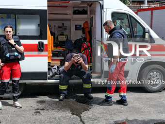 A firefighter is receiving first aid after putting out a fire at a warehouse caused by a Russian missile attack on civilian infrastructure i...