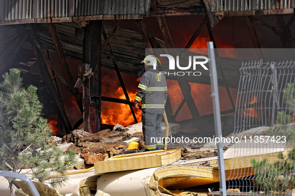 A firefighter is working to suppress a fire at a warehouse caused by a Russian missile strike in Odesa, Ukraine, on June 24, 2024. NO USE RU...