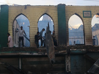 Civilians are working to extinguish a fire in Srinagar, Jammu and Kashmir, on June 24, 2024. A mosque and some buildings are being damaged i...