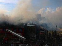 Indian firefighters and civilians are working to extinguish a fire in Srinagar, Jammu and Kashmir, on June 24, 2024. A mosque and some build...