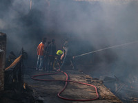 Indian firefighters and civilians are working to extinguish a fire in Srinagar, Jammu and Kashmir, on June 24, 2024. A mosque and some build...