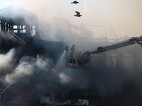 An Indian firefighter is working to extinguish a fire in Srinagar, Jammu and Kashmir, on June 24, 2024. A mosque and some buildings are bein...