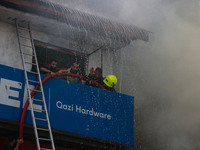 Indian firefighters and civilians are working to extinguish a fire in Srinagar, Jammu and Kashmir, on June 24, 2024. A mosque and some build...