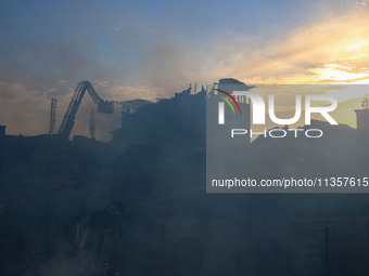 Indian firefighters and civilians are working to extinguish a fire in Srinagar, Jammu and Kashmir, on June 24, 2024. A mosque and some build...