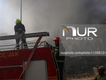 Firefighters are preparing to douse the fire in a congested neighborhood in Old City Srinagar, Indian Administered Kashmir, on June 24, 2024...