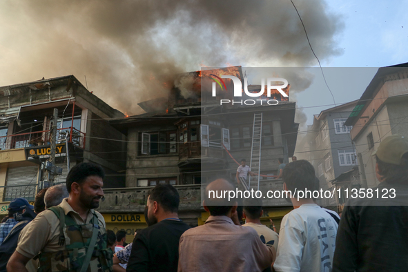 Local people are trying to douse the fire in a congested neighborhood in Old City Srinagar, Indian Administered Kashmir, on June 24, 2024. S...