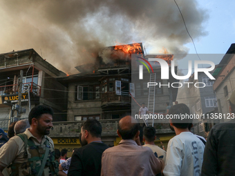 Local people are trying to douse the fire in a congested neighborhood in Old City Srinagar, Indian Administered Kashmir, on June 24, 2024. S...