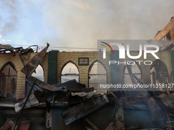 An old mosque is in shambles after a fire engulfed a congested neighborhood in Old City, Srinagar, Indian Administered Kashmir, on June 24,...