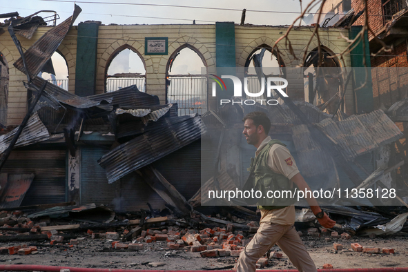 An old mosque is in shambles after a fire engulfed a congested neighborhood in Old City, Srinagar, Indian Administered Kashmir, on June 24,...