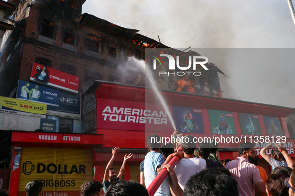 People are trying to douse the fire in a congested neighborhood in Old City Srinagar, Indian Administered Kashmir, on June 24, 2024. Several...