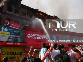 People are trying to douse the fire in a congested neighborhood in Old City Srinagar, Indian Administered Kashmir, on June 24, 2024. Several...