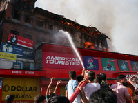 People are trying to douse the fire in a congested neighborhood in Old City Srinagar, Indian Administered Kashmir, on June 24, 2024. Several...