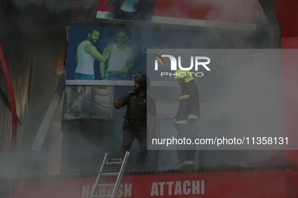 People are trying to douse the fire in a congested neighborhood in Old City Srinagar, Indian Administered Kashmir, on June 24, 2024. Several...