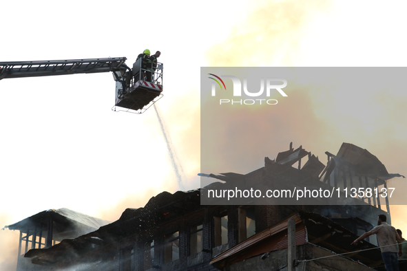 Firefighters are trying to douse the fire in a congested neighborhood in Old City Srinagar, Indian Administered Kashmir, on June 24, 2024. S...