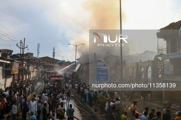 Firefighters are trying to douse the fire in a congested neighborhood in Old City Srinagar, Indian Administered Kashmir, on June 24, 2024. S...