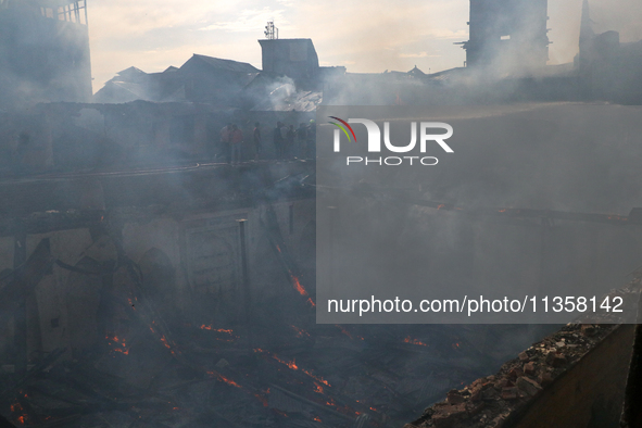 Firefighters are trying to douse the fire in a congested neighborhood in Old City Srinagar, Indian Administered Kashmir, on June 24, 2024. S...