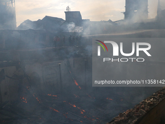 Firefighters are trying to douse the fire in a congested neighborhood in Old City Srinagar, Indian Administered Kashmir, on June 24, 2024. S...