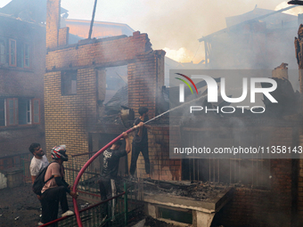 People are trying to douse the fire in a congested neighborhood in Old City Srinagar, Indian Administered Kashmir, on June 24, 2024. Several...