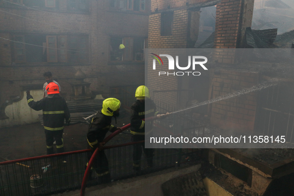 Firefighters are trying to douse the fire in a congested neighborhood in Old City Srinagar, Indian Administered Kashmir, on June 24, 2024. S...