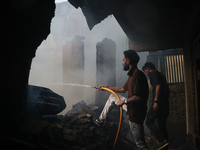 People are trying to douse the fire in a congested neighborhood in Old City Srinagar, Indian Administered Kashmir, on June 24, 2024. Several...