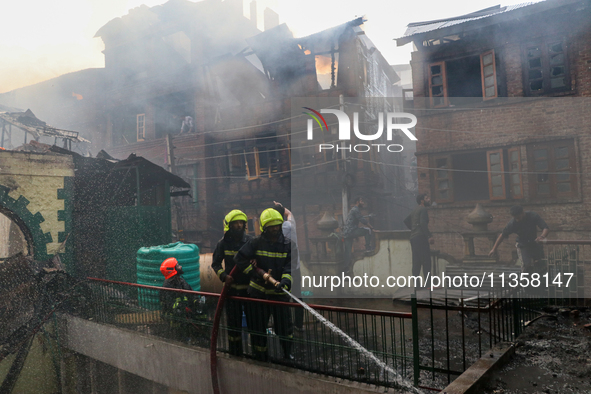 Firefighters are trying to douse the fire in a congested neighborhood in Old City Srinagar, Indian Administered Kashmir, on June 24, 2024. S...