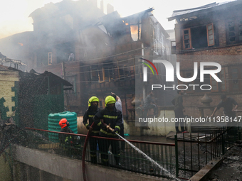 Firefighters are trying to douse the fire in a congested neighborhood in Old City Srinagar, Indian Administered Kashmir, on June 24, 2024. S...