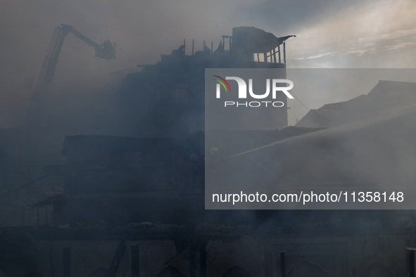 Firefighters are trying to douse the fire in a congested neighborhood in Old City Srinagar, Indian Administered Kashmir, on June 24, 2024. S...