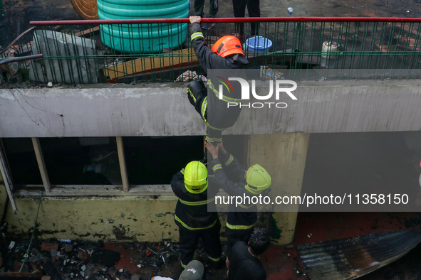 Firefighters are helping their colleague during the massive fire in a congested neighborhood in Old City Srinagar, Indian Administered Kashm...