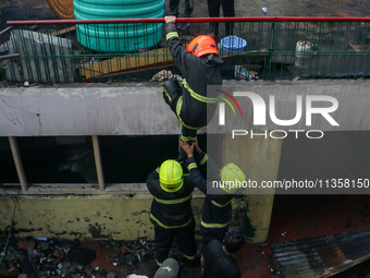 Firefighters are helping their colleague during the massive fire in a congested neighborhood in Old City Srinagar, Indian Administered Kashm...