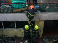 Firefighters are helping their colleague during the massive fire in a congested neighborhood in Old City Srinagar, Indian Administered Kashm...