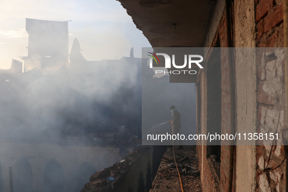 People are trying to douse the fire in a congested neighborhood in Old City Srinagar, Indian Administered Kashmir, on June 24, 2024. Several...