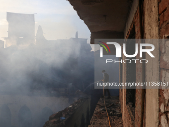 People are trying to douse the fire in a congested neighborhood in Old City Srinagar, Indian Administered Kashmir, on June 24, 2024. Several...